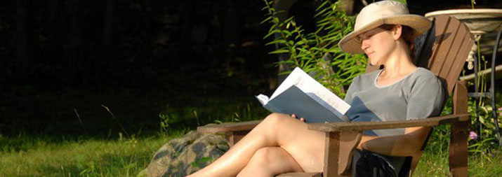 woman sitting outside reading a book